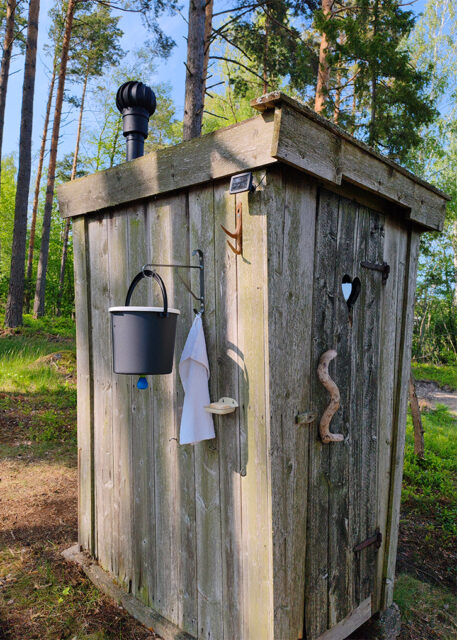 Uusittu kompostoiva kuivakäymälä ulkoa kesällä – tuuletusputki katolla, käsienpesuastia ovella, Aaslan saari Naantali